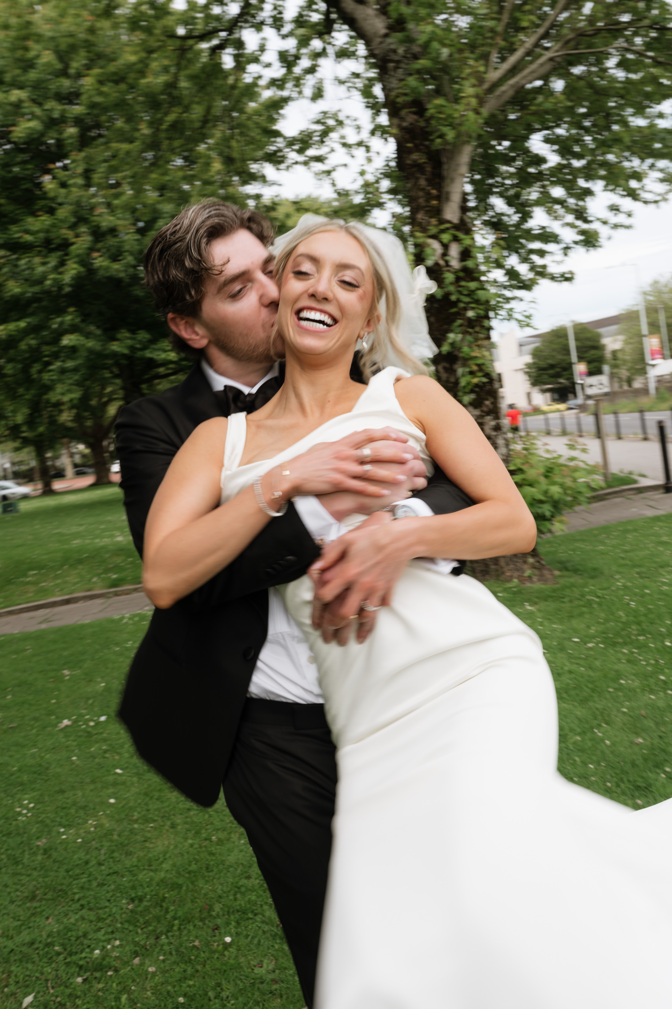 Hannah laughing as Andrew embraces her outside.