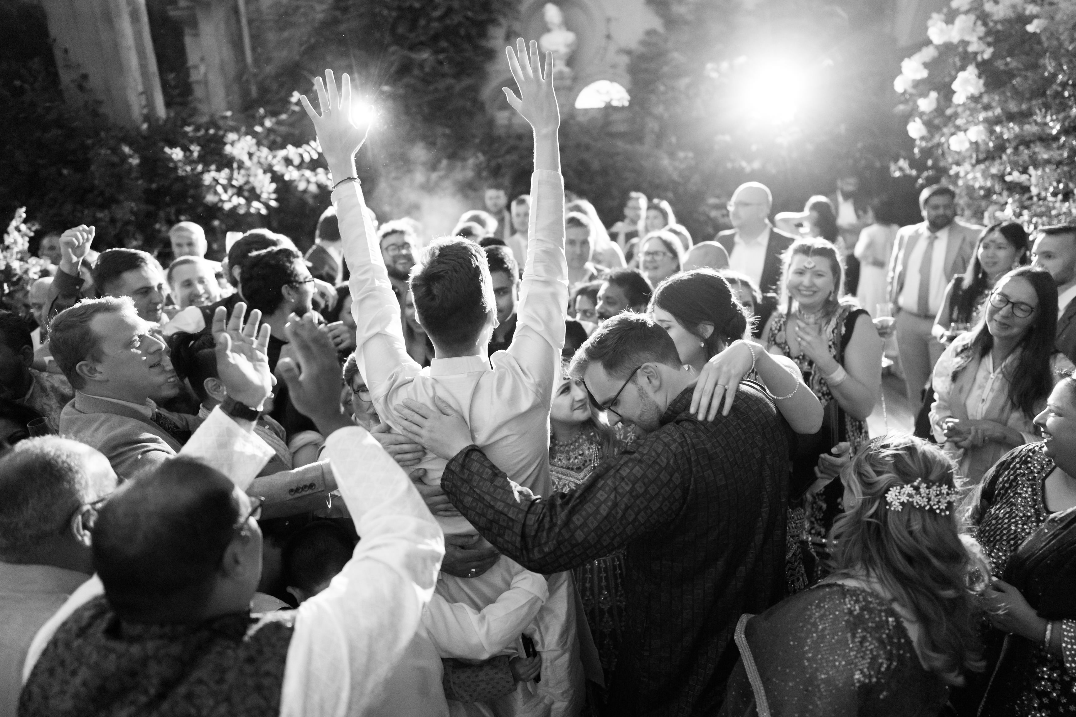 A happy crowd is celebrating as they lift someone into the air with their hands at a fun event.